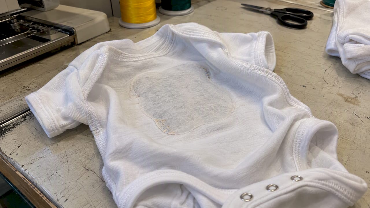 Soft backing covers embroidery on a onesie